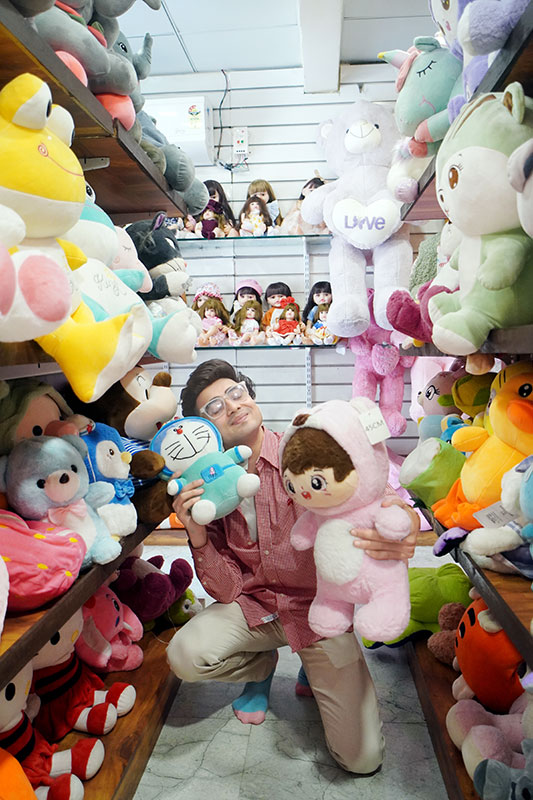 Cool handsome boy 2026 holding soft toys and smiling in toy shop showing cute Indian boy expression.